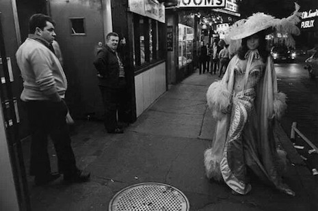 A burlesque dancer outside of a club in the Combat Zone, 1970s