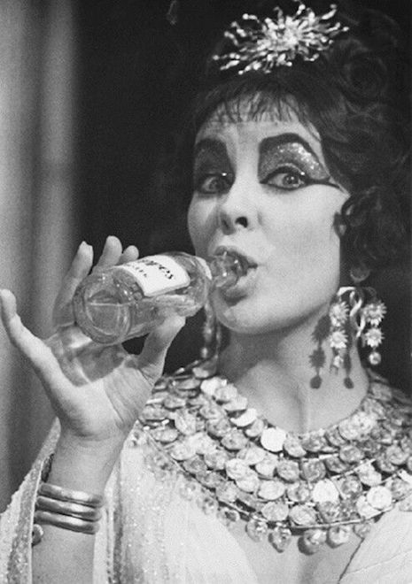 Elizabeth Taylor having a drink on the set of the 1963 film, Cleopatra