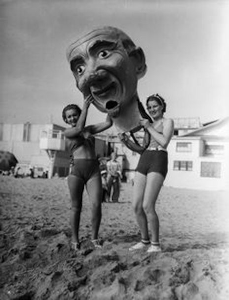 Giant paper mache masks at the Venice Beach Mardi Gras, 1930s