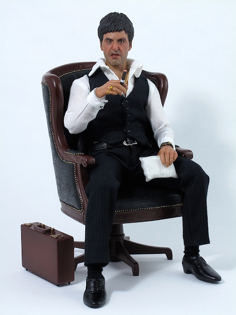 Tony Montana War figure sitting with packages of coke and heroin