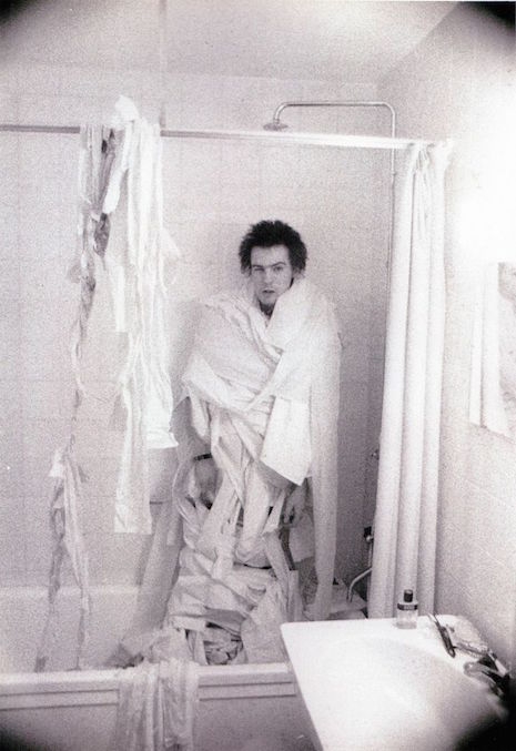Sid Vicious wrapped in toilet paper in the bathroom shower
