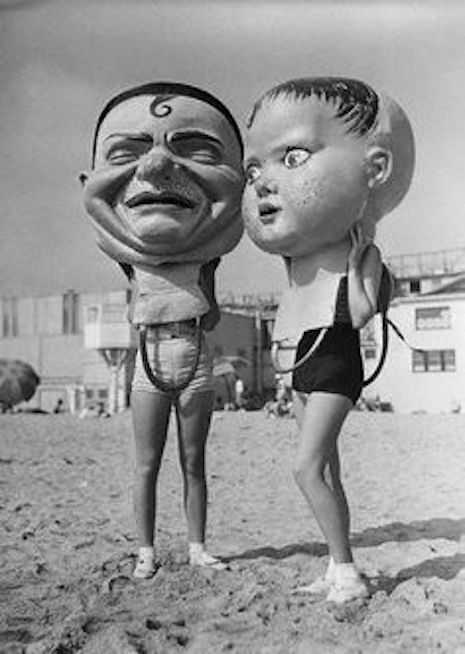 Giant paper mache masks hanging out on Venice Beach during Mardi Gras, 1935