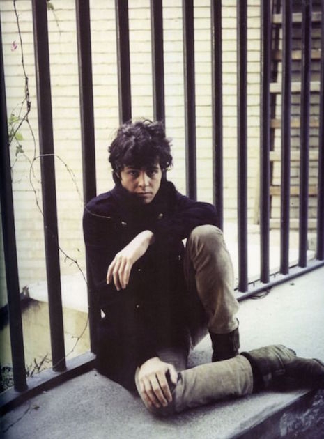 A young Marc Bolan sitting on a ledge looking very mod