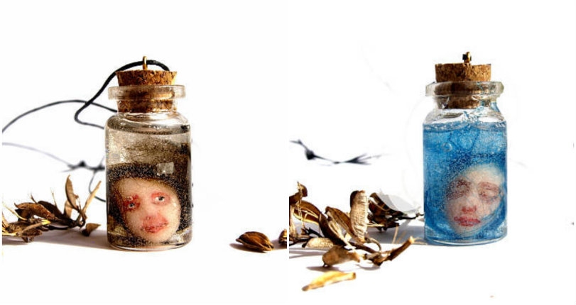 Tiny doll heads in little jars become completely creepy pieces of jewelry