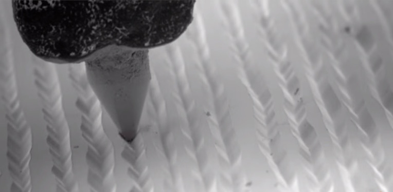Microscopic footage of a needle moving across the grooves of a record