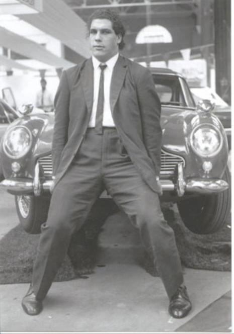 A young André the Giant lifing the front end of a car