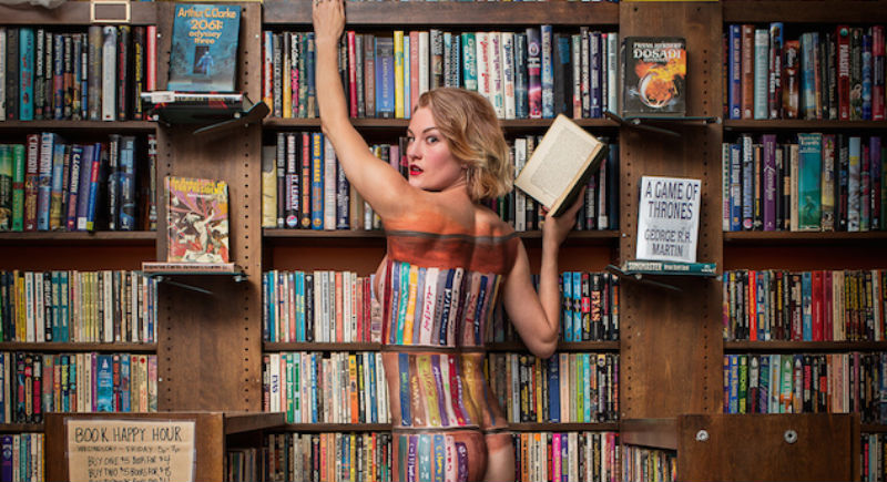 Naked lady perfectly blends into bookshelf