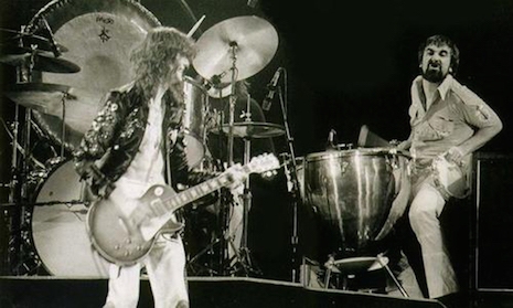 Keith Moon sitting at John Bonham's drum kit while Jimmy Page looks on, June 23rd, 1977