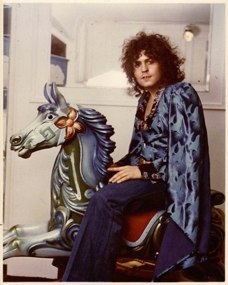 Marc Bolan riding on top of a carousel horse